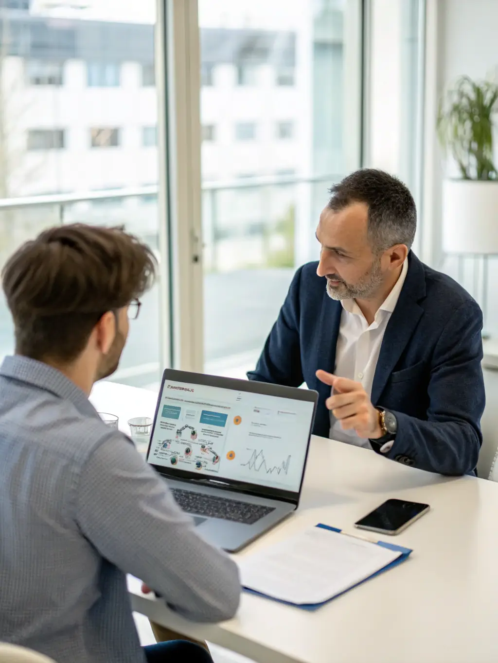 A consultant discussing technology strategies with a client in a modern office setting, emphasizing collaboration and strategic planning.
